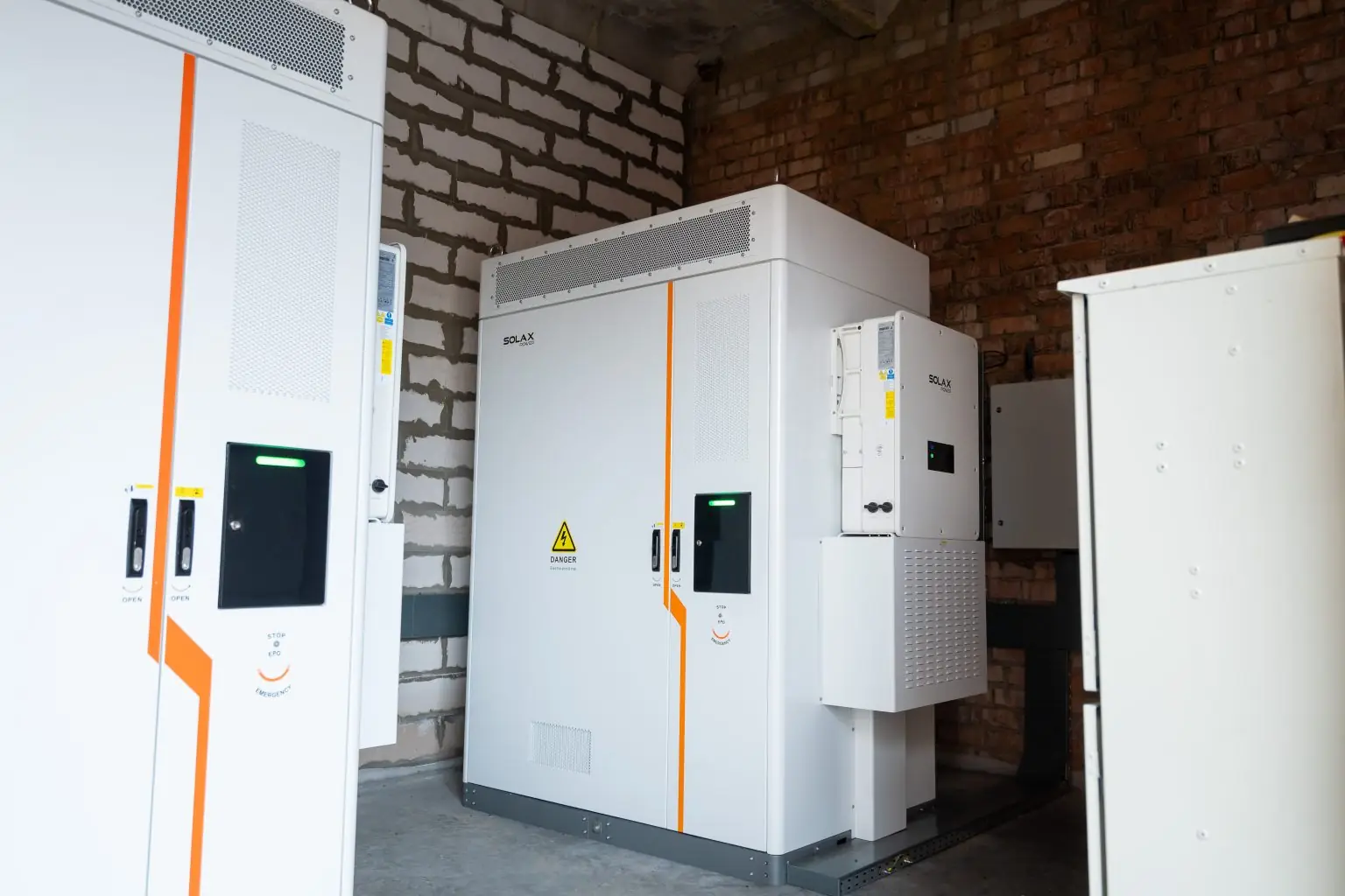 Batteriskap og inverter installert innendørs ved en teglvegg