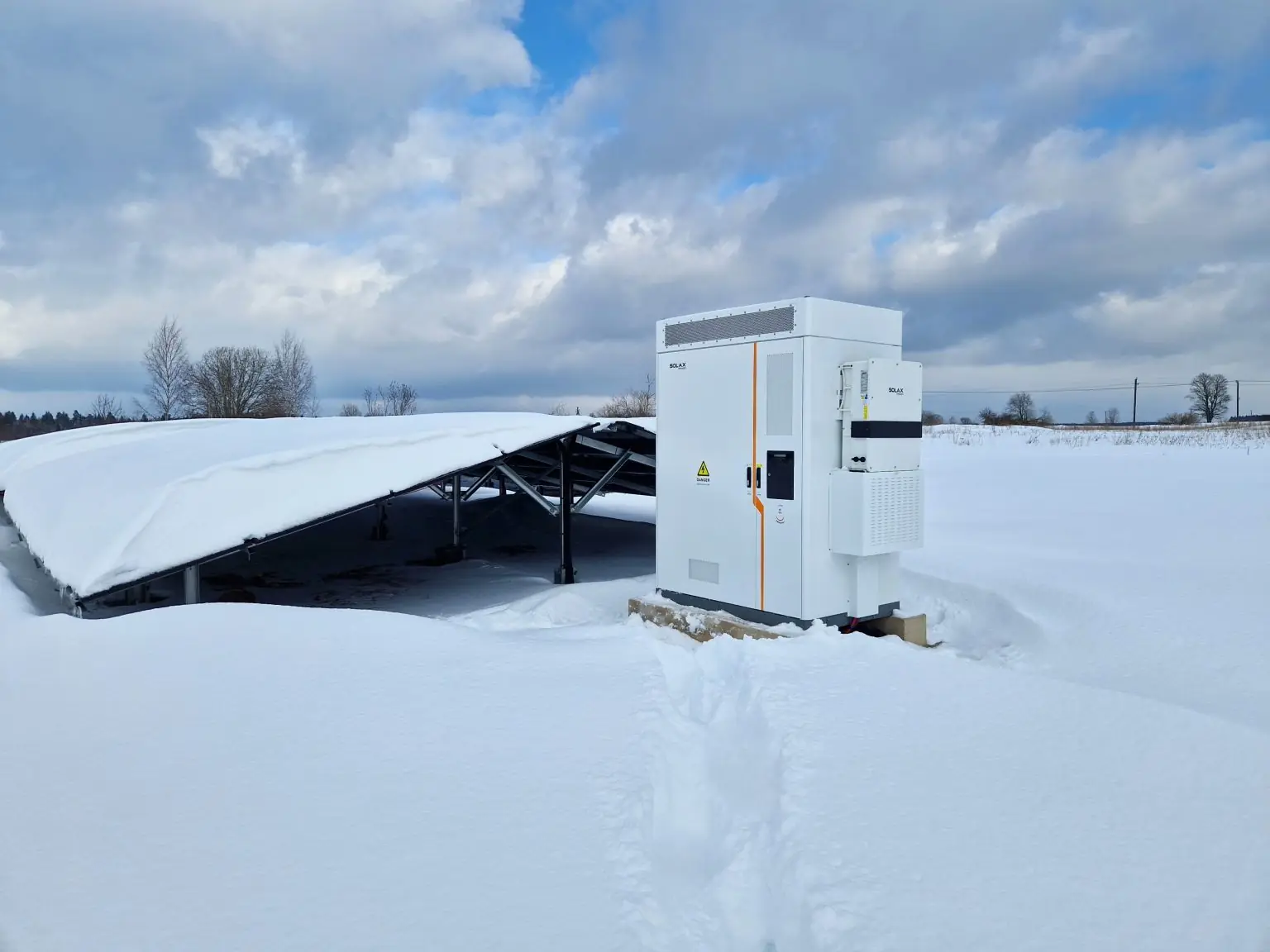 Batteriskap ved et snødekt bakkemontert solcelleanlegg