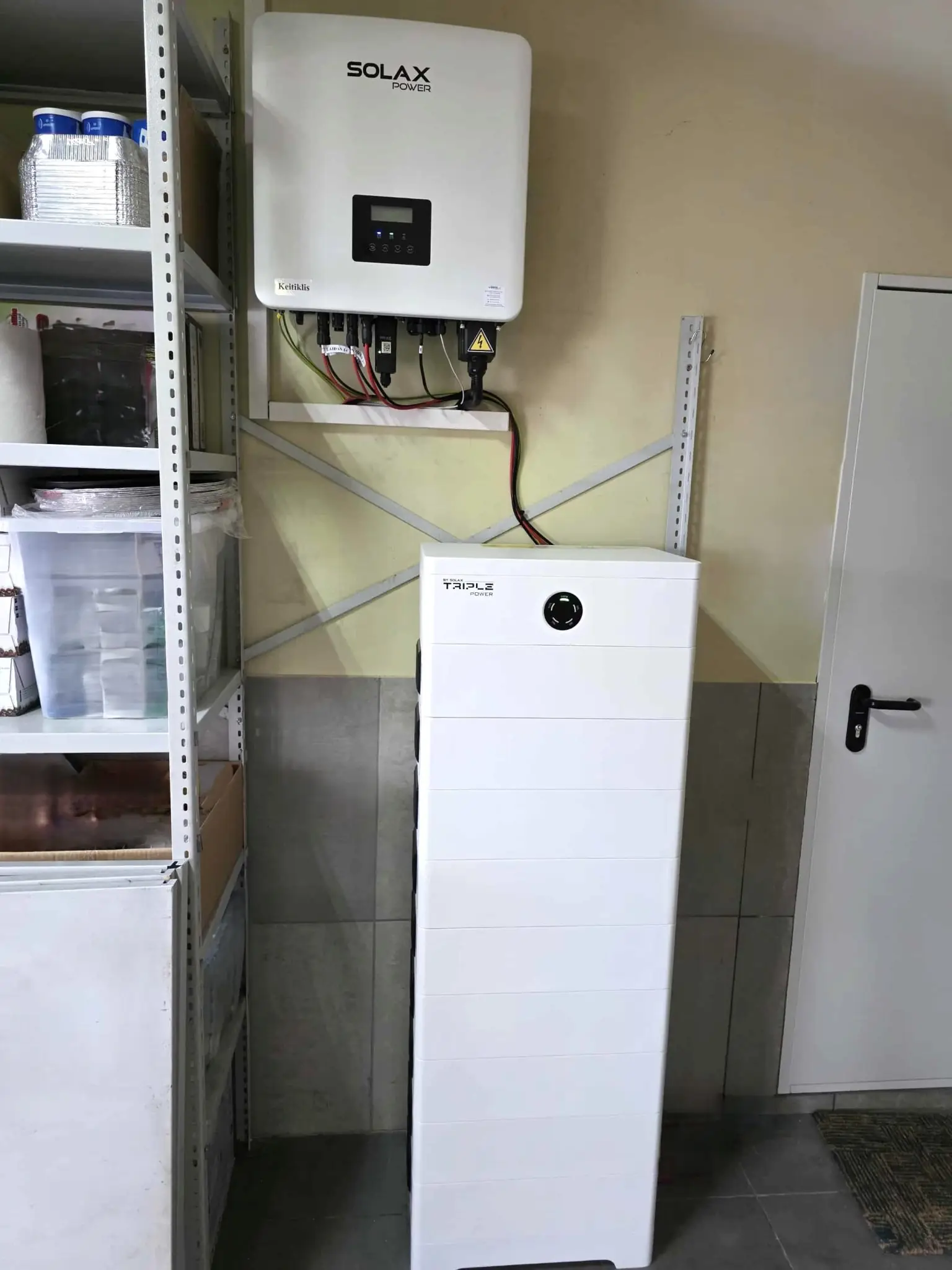 Hvitt batterilager under en inverter i en bod