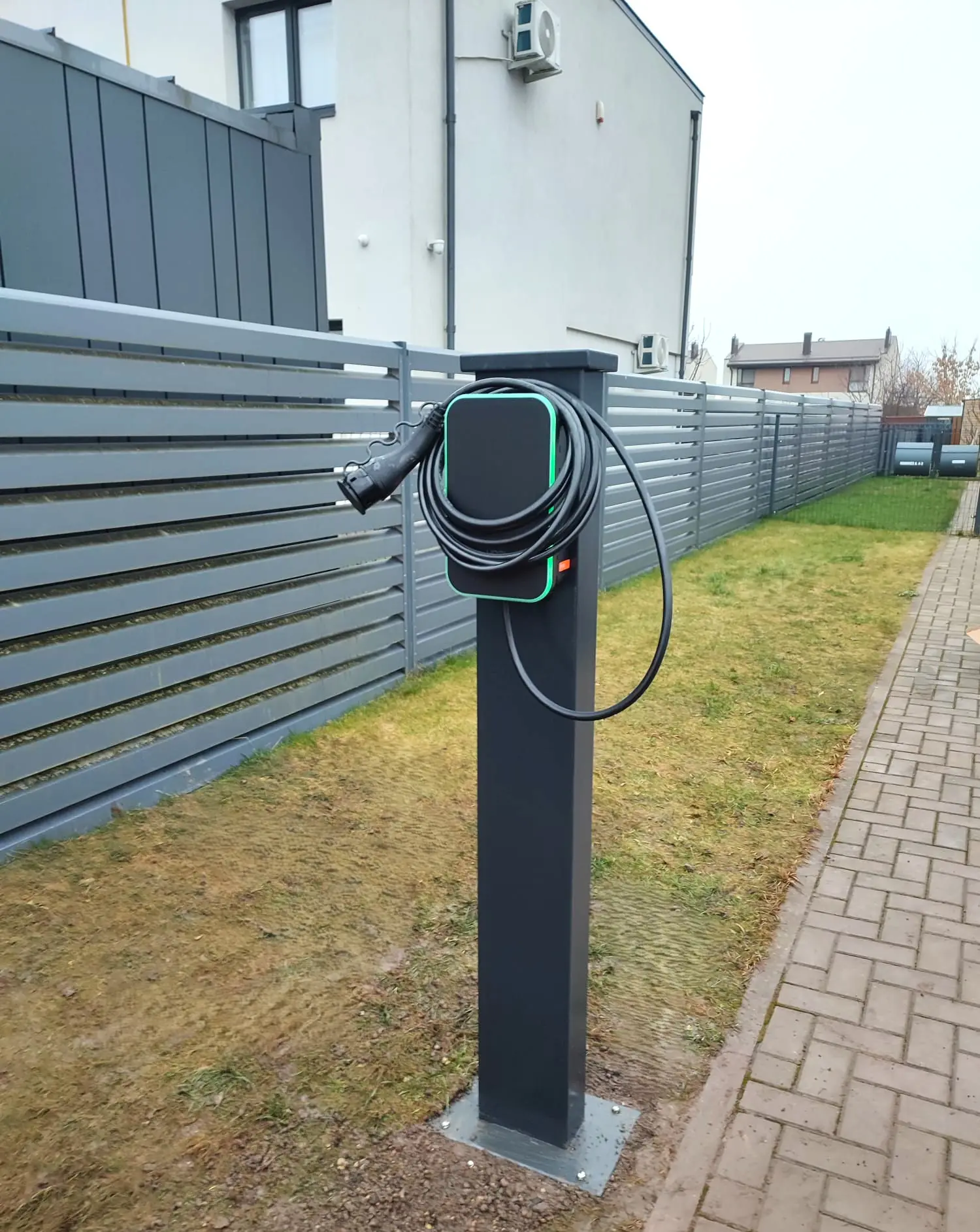 Elbillader på en stolpe ved et gjerde